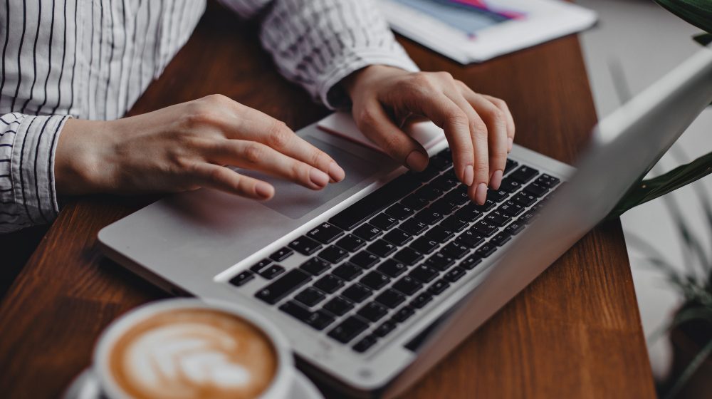 female-hands-press-laptop-keys-while-sitting-wooden-table-with-white-cappuccino-cup Alibaba to roll out ChatGPT rival very soon
